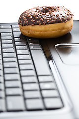 Image showing break in the  office . doughnut on laptop keyboard