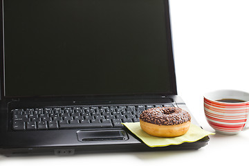 Image showing break in the  office . doughnut on laptop keyboard