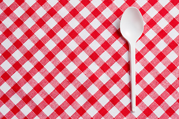Image showing plastic spoon on checkered tablecloth