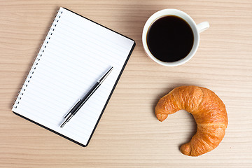 Image showing croissant with coffee and notepad