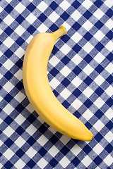 Image showing yellow banana on checkered tablecloth