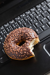 Image showing break in the  office . doughnut on laptop keyboard