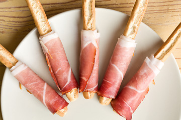 Image showing grissini sticks with ham