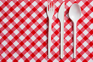 Image showing plastic cutlery on checkered tablecloth