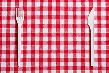 Image showing plastic cutlery on checkered tablecloth