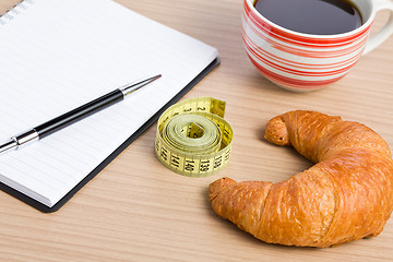 Image showing diet concept . croissant and measuring tape