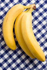 Image showing yellow bananas on checkered tablecloth