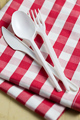 Image showing plastic cutlery on checkered tablecloth