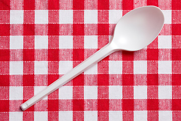 Image showing plastic spoon on checkered tablecloth