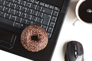 Image showing break in the  office . doughnut on laptop keyboard