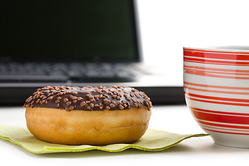 Image showing break in the  office . doughnut on laptop keyboard