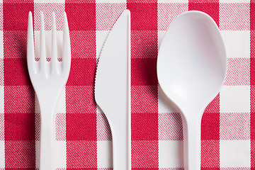 Image showing plastic cutlery on checkered tablecloth