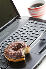 Image showing break in the  office . doughnut on laptop keyboard