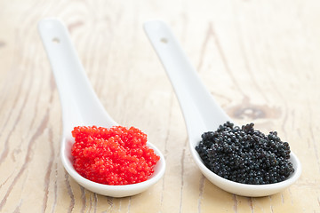 Image showing red and black caviar in ceramic spoon