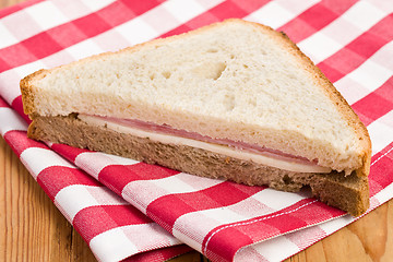 Image showing ham sandwich on checkered napkin