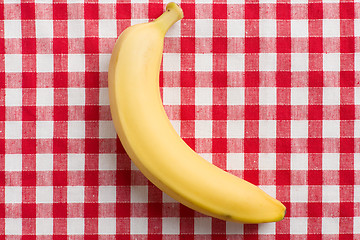 Image showing yellow banana on checkered tablecloth
