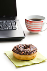 Image showing break in the  office . doughnut on laptop keyboard