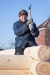 Image showing Man builds a wooden house