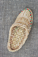 Image showing Wicker bast shoe on linen fabric