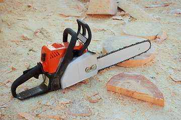 Image showing Chainsaw is on background wooden shavings