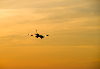 Image showing Jetliner flying against red sunset sky