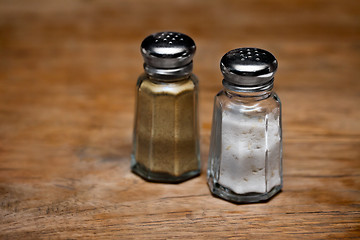 Image showing Saltshaker and pepper shaker on a wooden table.