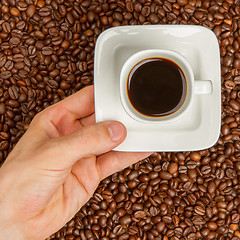 Image showing Cup of coffee on beans. top view