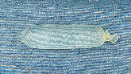 Image showing Condom filled with water on jeans 