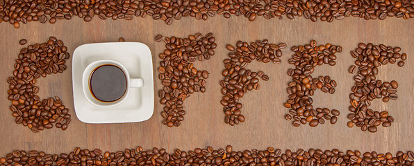 Image showing The word Coffee spelled with hundreds of coffee beans and one cu