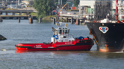 Image showing Two tugboats manoeuvring an oil tanker in the dutch harbor of Ro