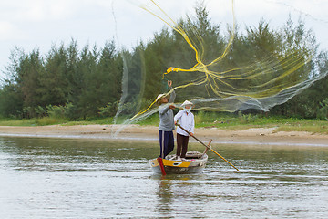 Image showing Fisherman is fishing with a large net in a river in Vietnam