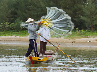 Image showing Fisherman is fishing with a large net in a river in Vietnam