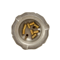 Image showing Burning cigarette and empty 9mm bullet casings in an old tin ash