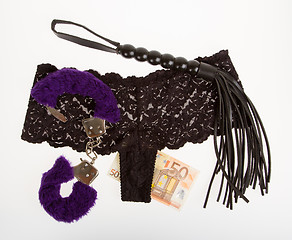 Image showing Fluffy purple handcuffs, a whip, money and panties, prostitution