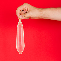 Image showing White condom with water in hand