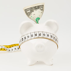 Image showing White piggy bank with measuring tape