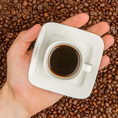 Image showing Cup of coffee on beans. top view