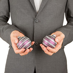 Image showing Man in grey suit is holding Christmass balls