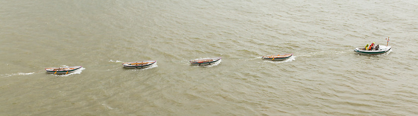 Image showing Motorboat dragging some rowing-boats