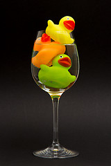 Image showing Yellow, orange and green rubber duck in a wineglass