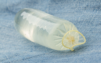 Image showing Condom filled with water on jeans 