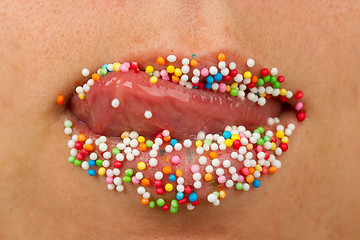 Image showing Woman lips with multicolored pearls 