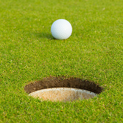 Image showing Golf ball in front of the hole, focus on the hole