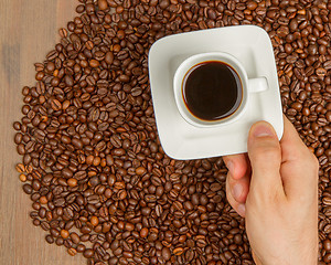 Image showing Cup of coffee on beans. top view