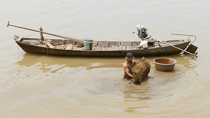 Image showing A vietnamese fisherman is searching for shells in the water