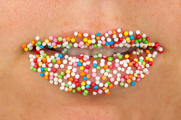 Image showing Woman lips with multicolored pearls 