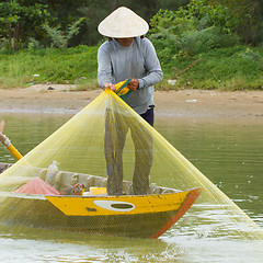 Image showing Fisherman is fishing with a large net in a river in Vietnam