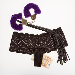 Image showing Fluffy purple handcuffs, a whip, money and panties, prostitution