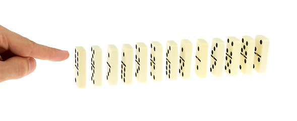 Image showing Hand ready to push dominoes