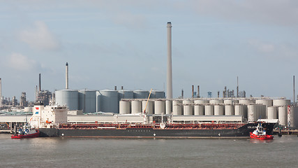 Image showing Two tugboats manoeuvring an oil tanker in the dutch harbor of Ro